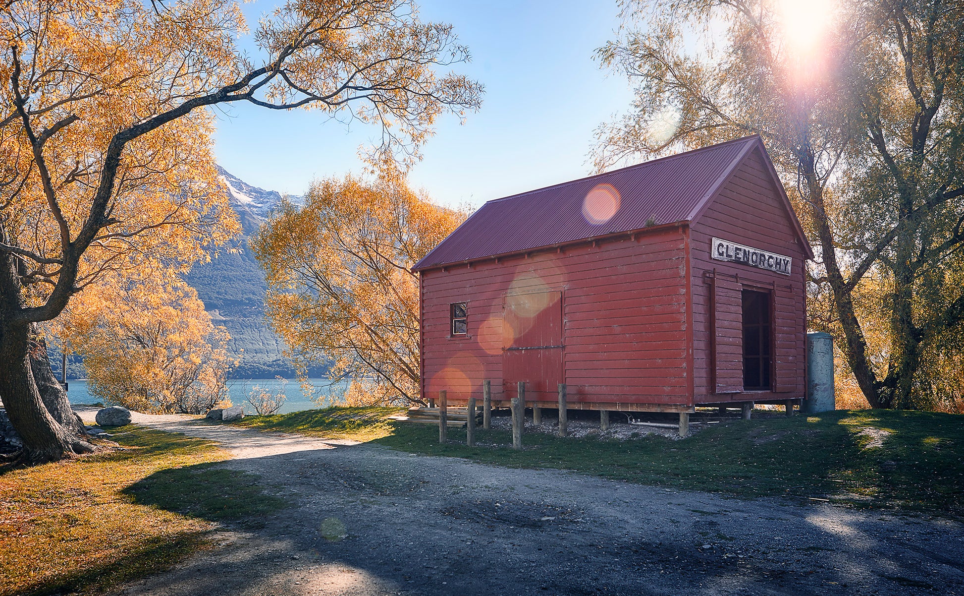 Historic red shed in Glenorchy surrounded by autumn colours during private guided tour from Queenstown