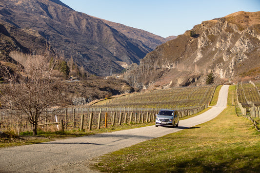 Luxury Mercedes tour vehicle driving through the scenic vineyards of Gibbston Valley, Queenstown wine region