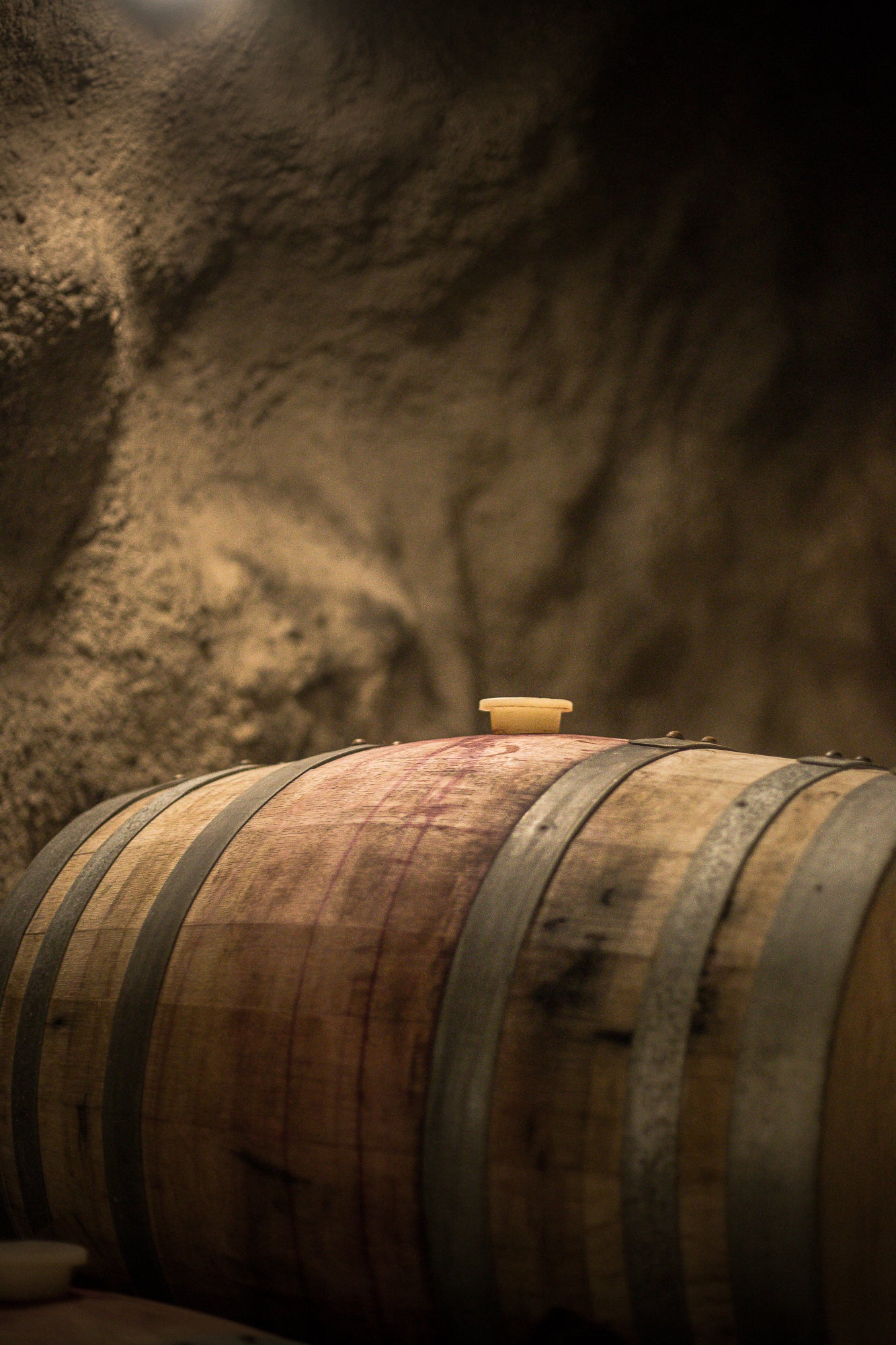 Aging Pinot Noir barrels inside New Zealand’s largest underground wine cave in Gibbston Valley