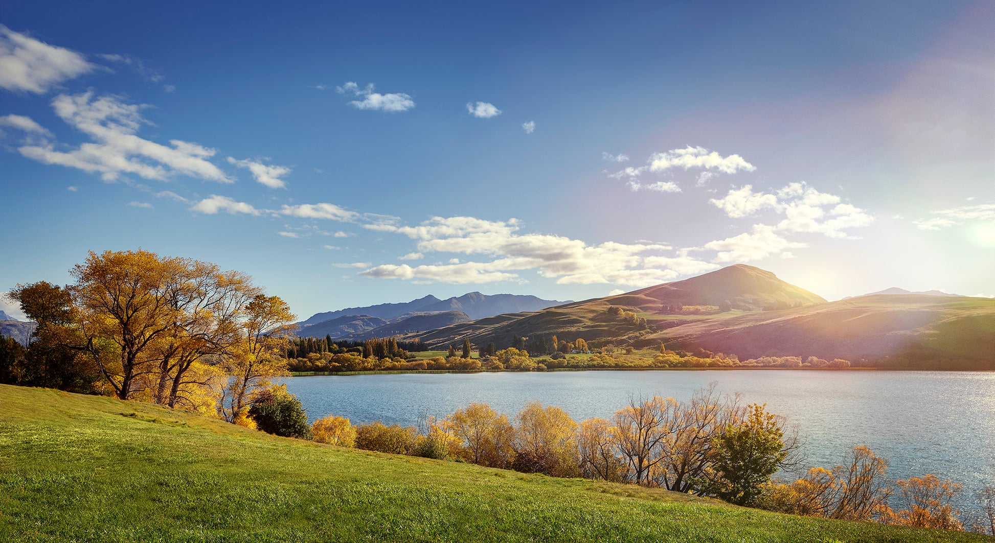 Scenic Arrowtown countryside with rolling hills, golden fields and evening light