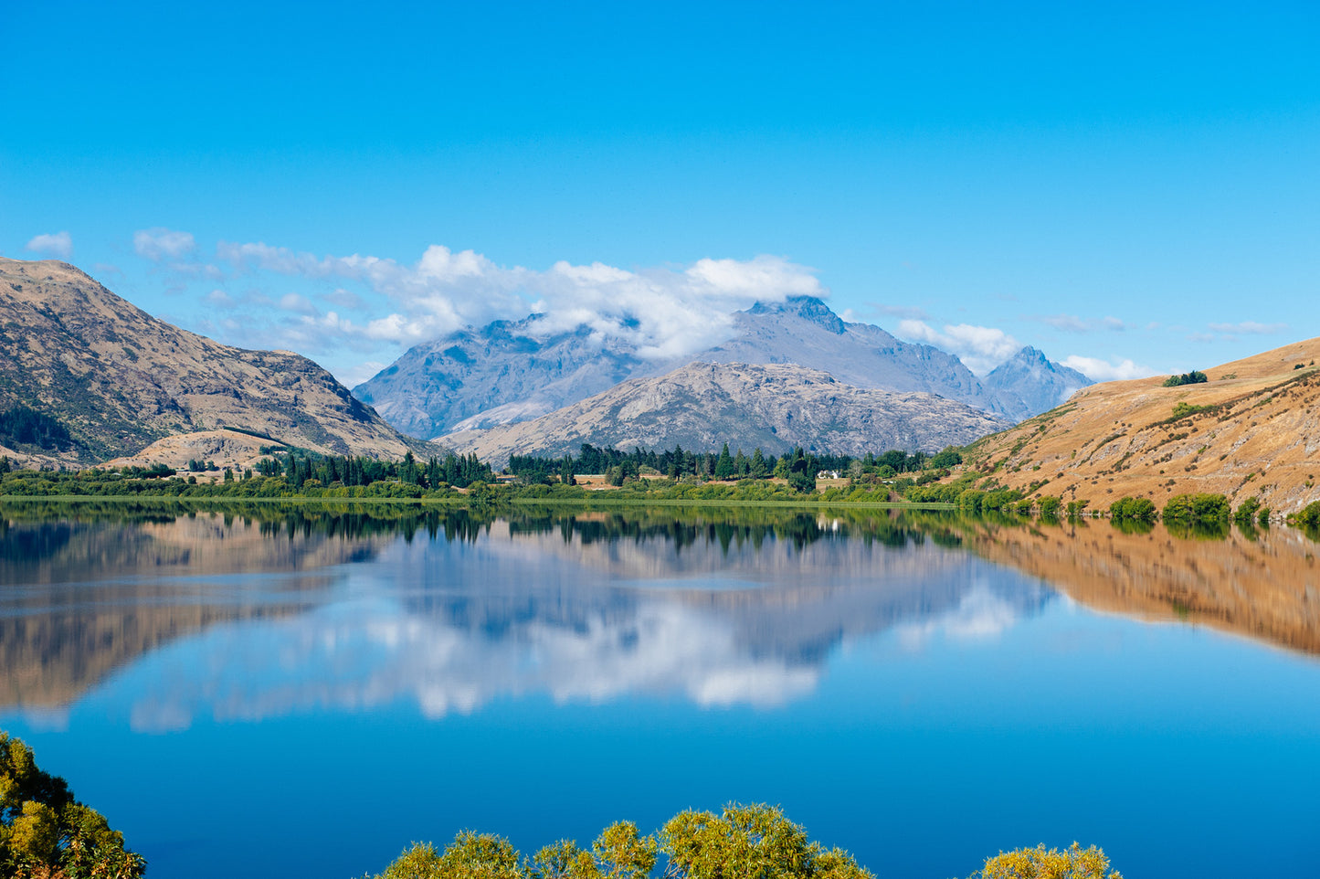 Lake Hayes reflecting mountains and autumn colours near Arrowtown