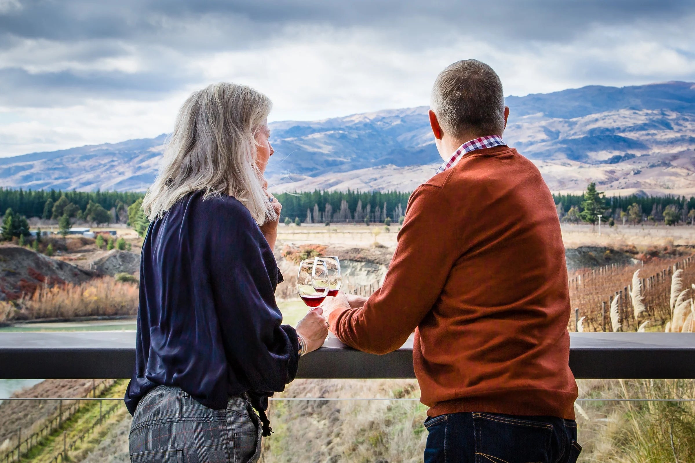 Couple enjoying a private Queenstown wine tour with panoramic mountain views in Central Otago